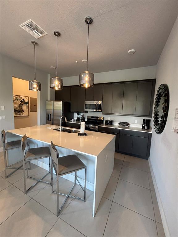 7740 Sandy Ridge Drive, Unit 131 Reunion, FL 34747 - Photo 4 of 27 a kitchen with stainless steel appliances kitchen island granite countertop a sink a counter top space cabinets and a rug