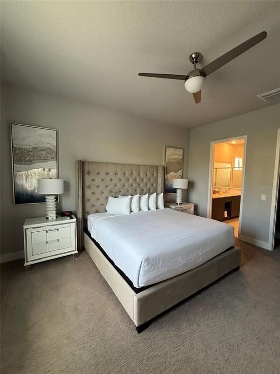 7740 Sandy Ridge Drive, Unit 131 Reunion, FL 34747 - Photo 8 of 27 a bedroom with a bed and a chandelier