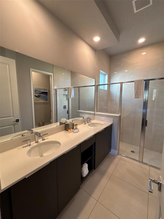 7740 Sandy Ridge Drive, Unit 131 Reunion, FL 34747 - Photo 10 of 27 a large bathroom with a double vanity sink and a mirror