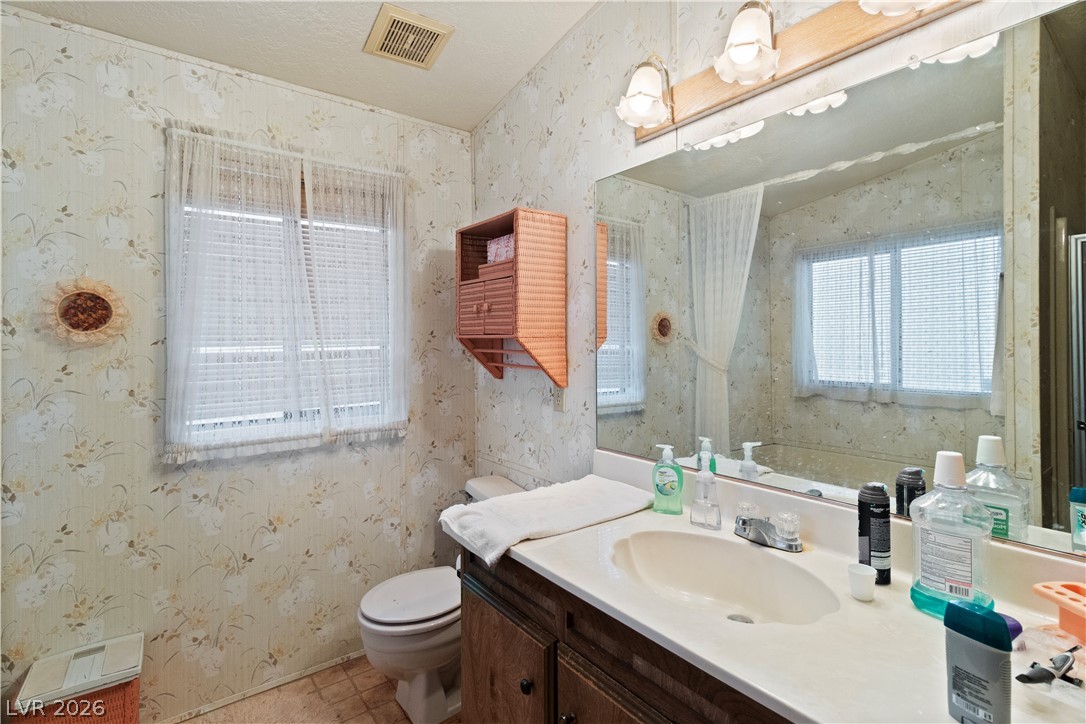 1609 Cajon Court Laughlin, NV 89029 - Photo 19 of 69 Primary Ensuite Bathroom with vanity, healthy amount of natural light, and wallpapered walls