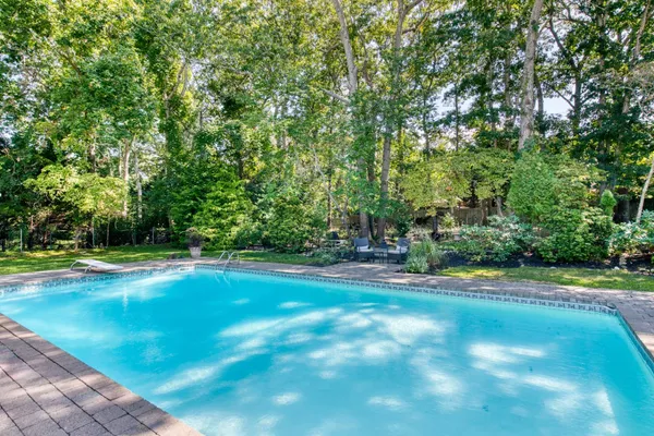 a view of a tennis ground with large trees