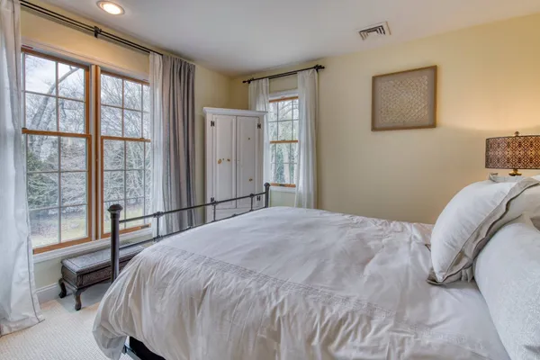 a bedroom with a bed and a large window