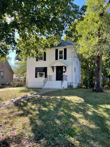 a view of a yard in front of a house with large trees