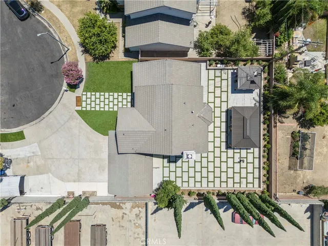a view of a patio with a table and chairs under an umbrella with a barbeque