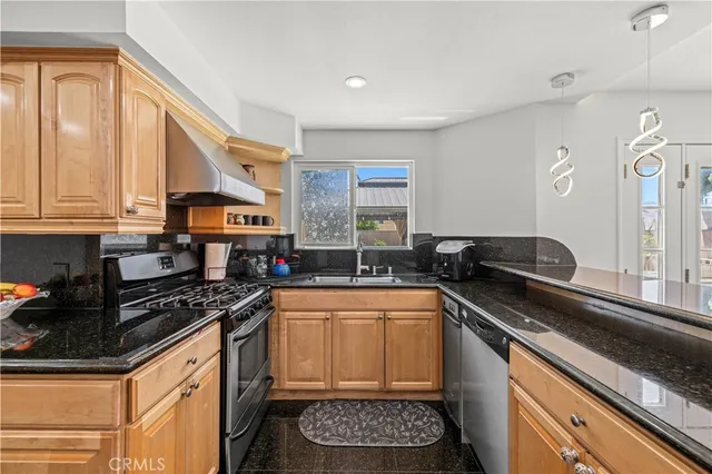 a kitchen with stainless steel appliances a refrigerator a sink a stove and cabinets