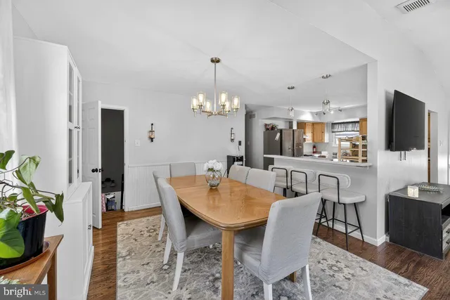 a dining room with furniture a chandelier and wooden floor