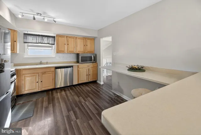 a kitchen with wooden floors and white appliances