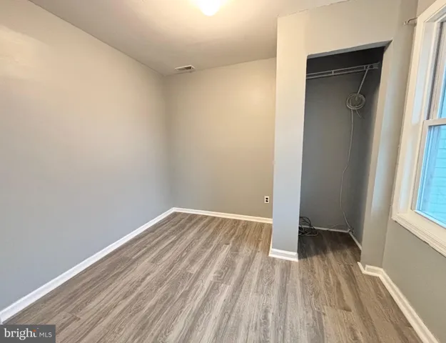 an empty room with wooden floor and a window