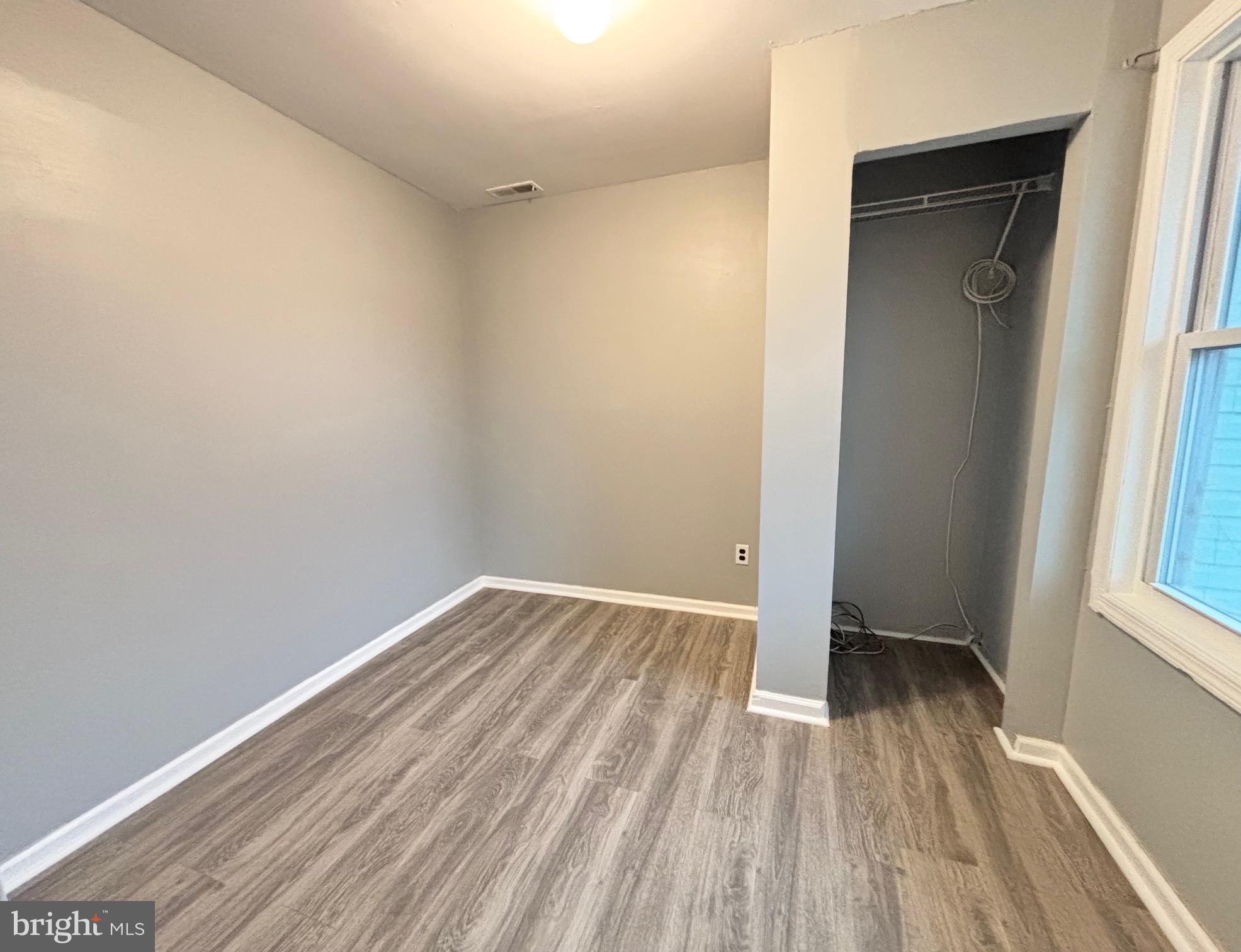 61 Berkshire Road Sicklerville, NJ 08081 - Photo 5 of 14 an empty room with wooden floor and a window
