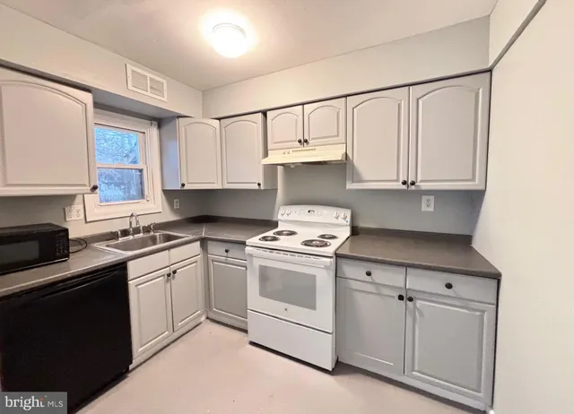 a kitchen with white cabinets and white appliances