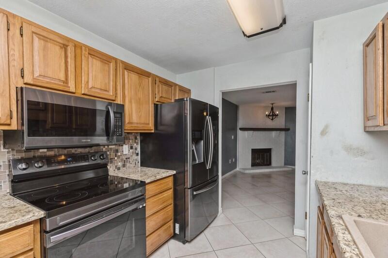 14 Gardner Drive Shalimar, FL 32579 - Photo 10 of 27 a kitchen with granite countertop a refrigerator and a stove top oven
