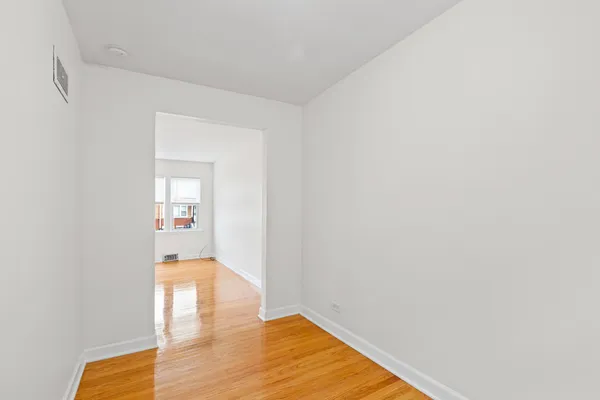 a view of a room with wooden floor and a potted plant