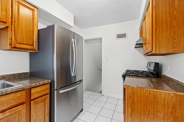 a kitchen with stainless steel appliances granite countertop a refrigerator and a stove