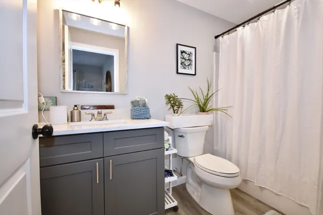 a bathroom with a sink vanity mirror and toilet