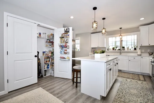 a kitchen with cabinets and wooden floor