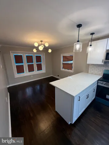 a kitchen with a stove and wooden floor