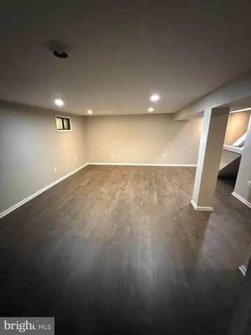 an empty room with wooden floor and entrance