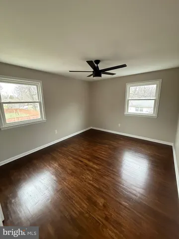a view of a room with wooden floor and windows