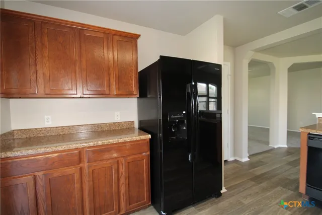 a kitchen with granite countertop cabinets and refrigerator
