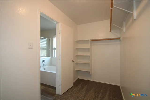 a view of walk in closet with empty racks