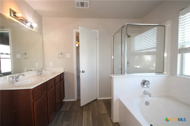 a bathroom with a tub sink and mirror
