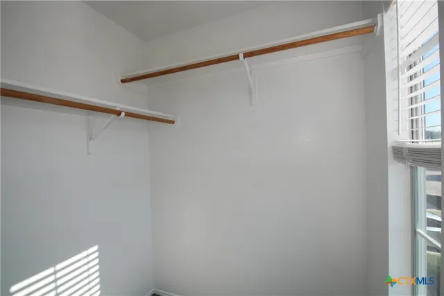 a view of a room with racks on the wall and a window