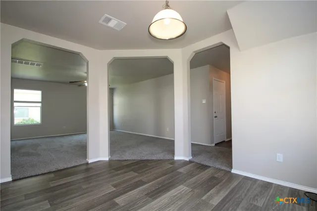 an empty room with wooden floor and mirror
