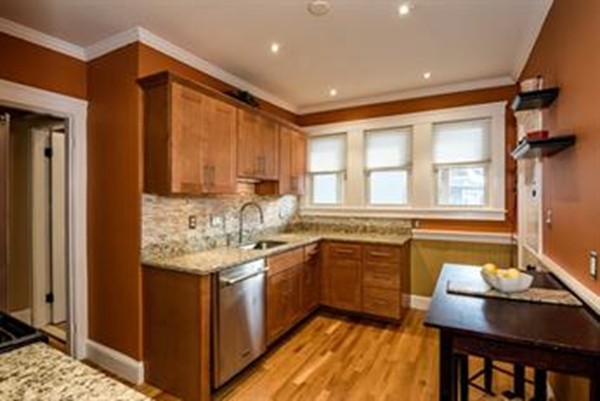 a kitchen with granite countertop sink stove and cabinets