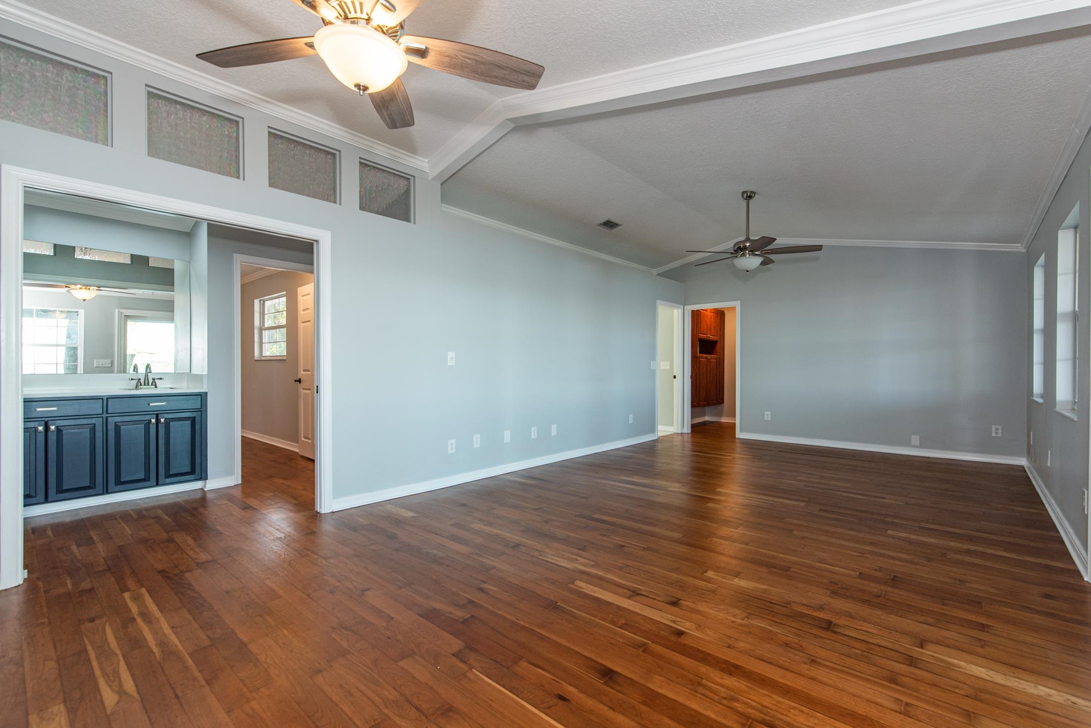 141 Jupiter Road St. Augustine, FL 32086 - Photo 26 of 48 a view of an empty room with wooden floor and a ceiling fan