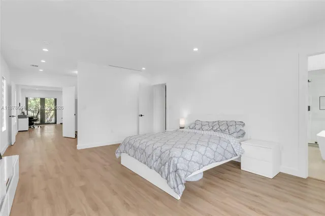 a bedroom with a bed and a wooden floor