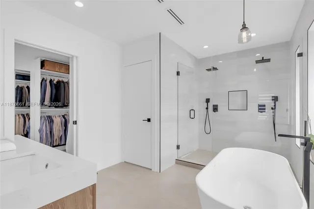 a spacious bathroom with a bathtub sink and mirror