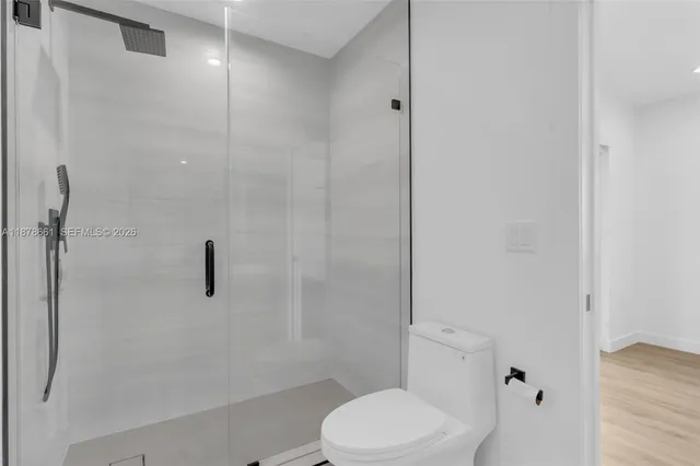 a white toilet sitting next to a bath tub