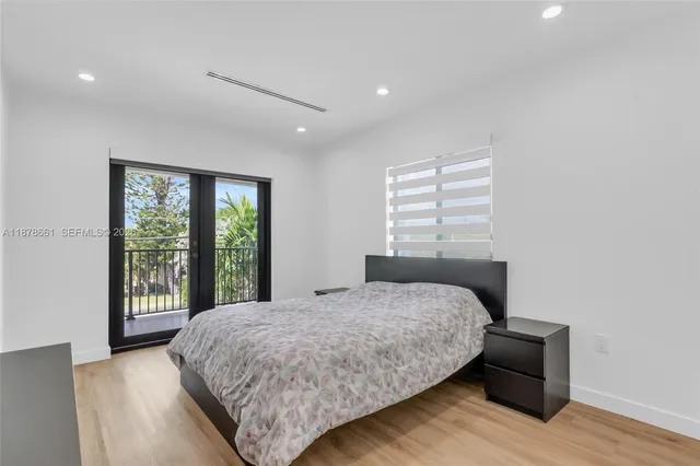 a bedroom with a bed and a large window