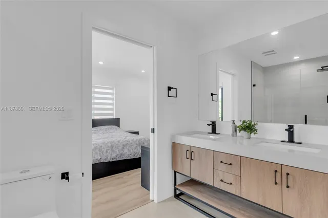a en suite bathroom with a granite countertop sink and a mirror