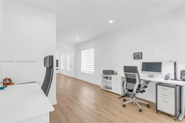 a view of a workspace with furniture and a window