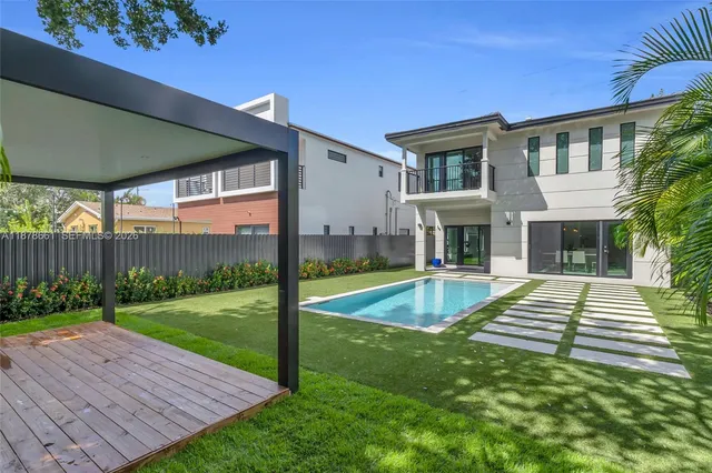a view of house with yard and swimming pool