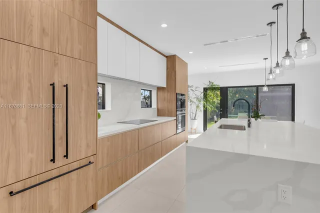 a large white kitchen with cabinets a sink and a refrigerator