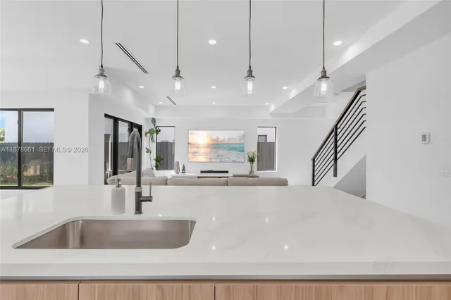 a kitchen with kitchen island a large counter space appliances and windows