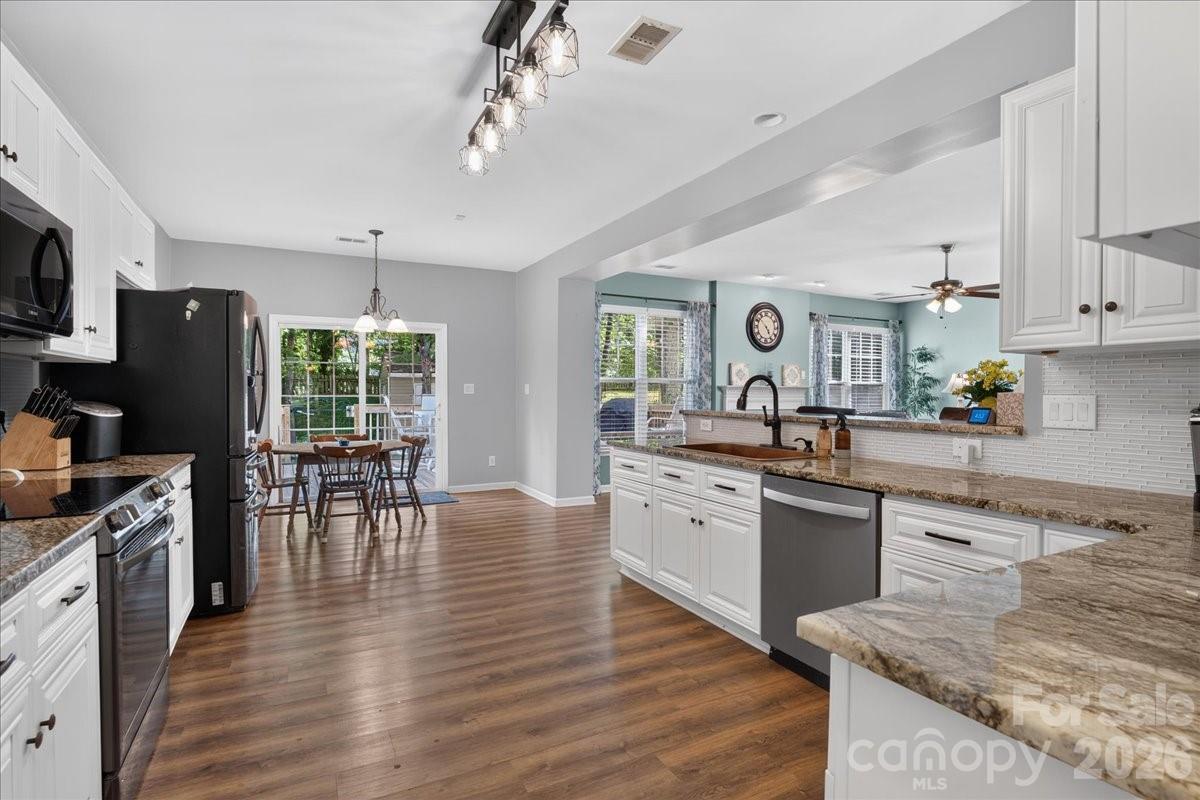 8006 Fine Robe Drive Indian Trail, NC 28079 - Photo 13 of 36 a large kitchen with cabinets wooden floor and stainless steel appliances