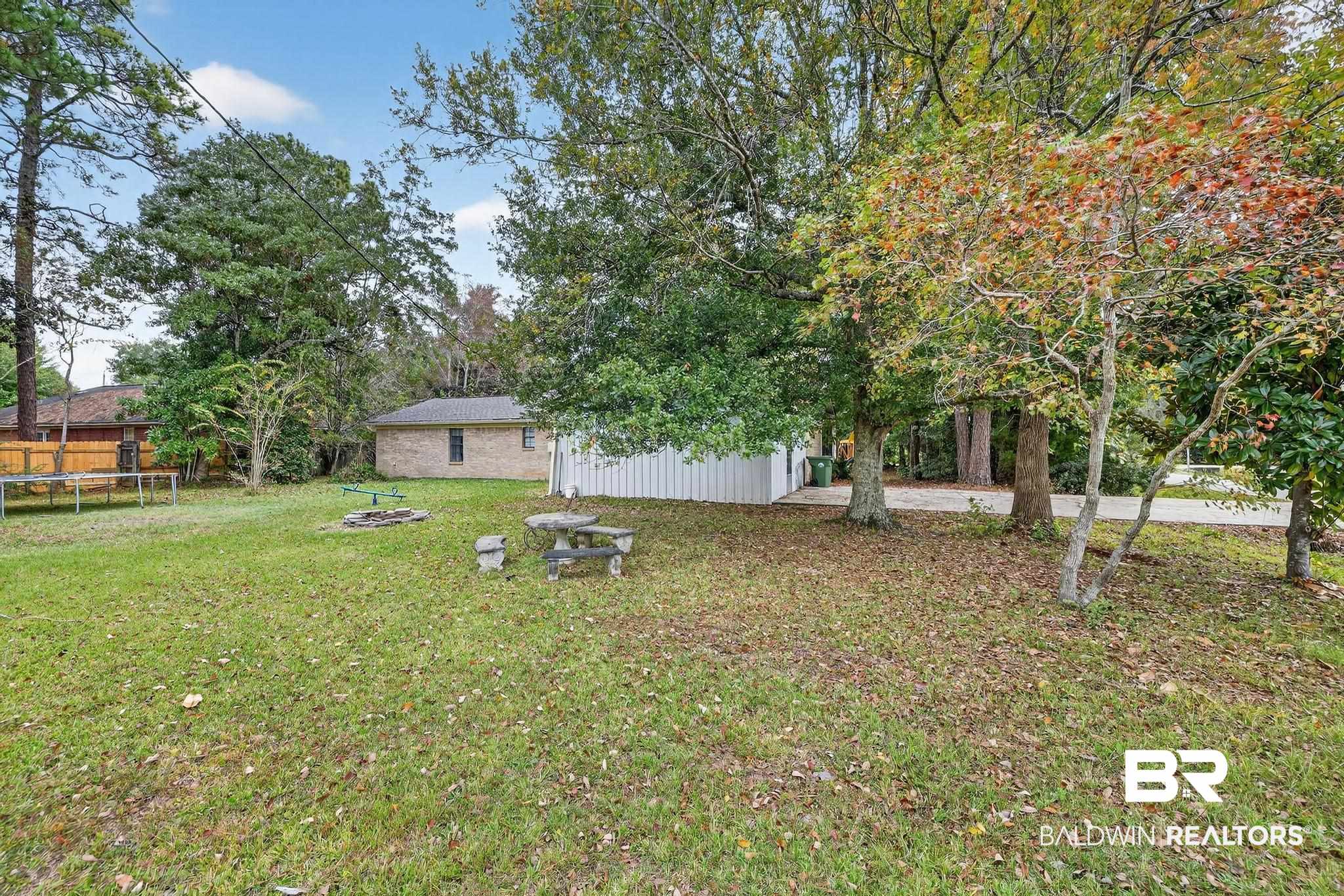 21895 2nd Street Silverhill, AL 36576 - Photo 9 of 43 View of green lawn featuring a fire pit