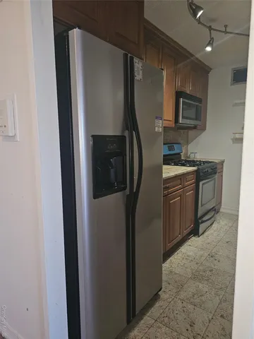 a kitchen with stainless steel appliances granite countertop a refrigerator and a sink