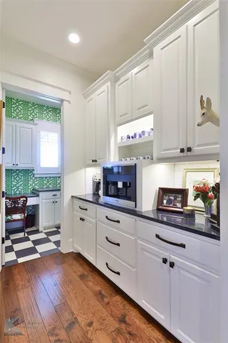 a kitchen with stainless steel appliances granite countertop a stove a sink and white cabinets