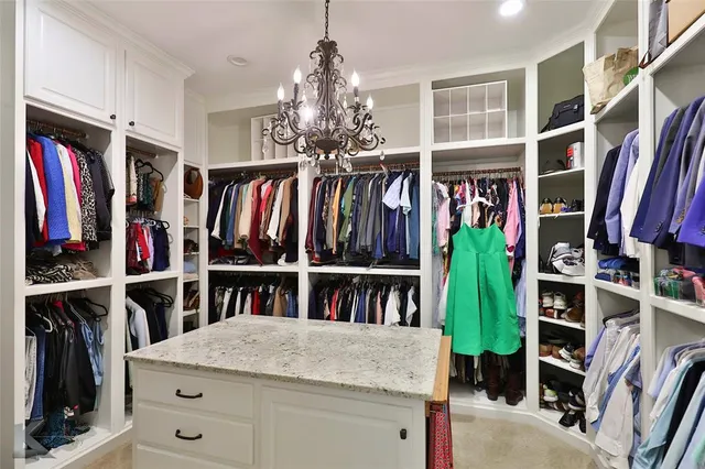 a view of walk in closet with clothes and shoes