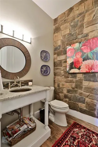 a bathroom with a toilet a sink and mirror