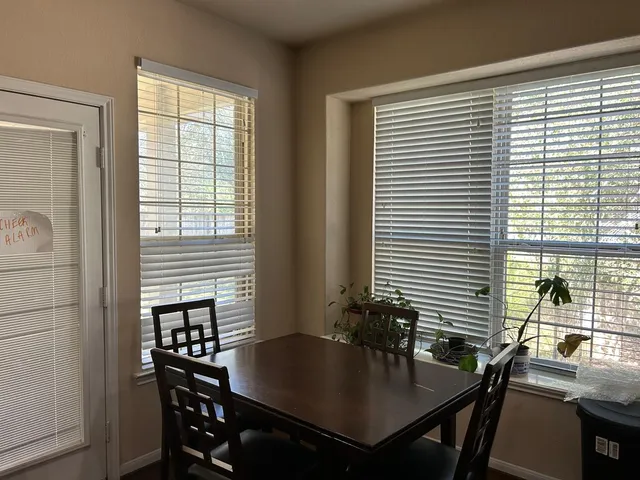a view of a dining room with a table and chairs