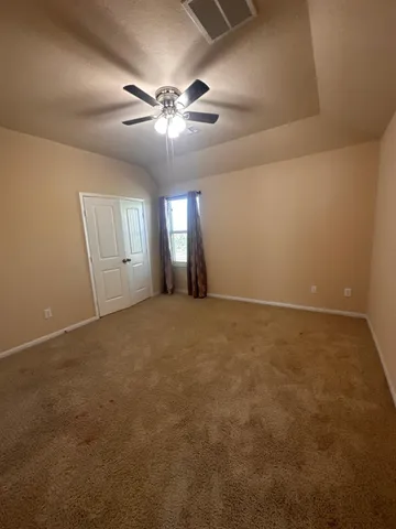 an empty room with windows and fan