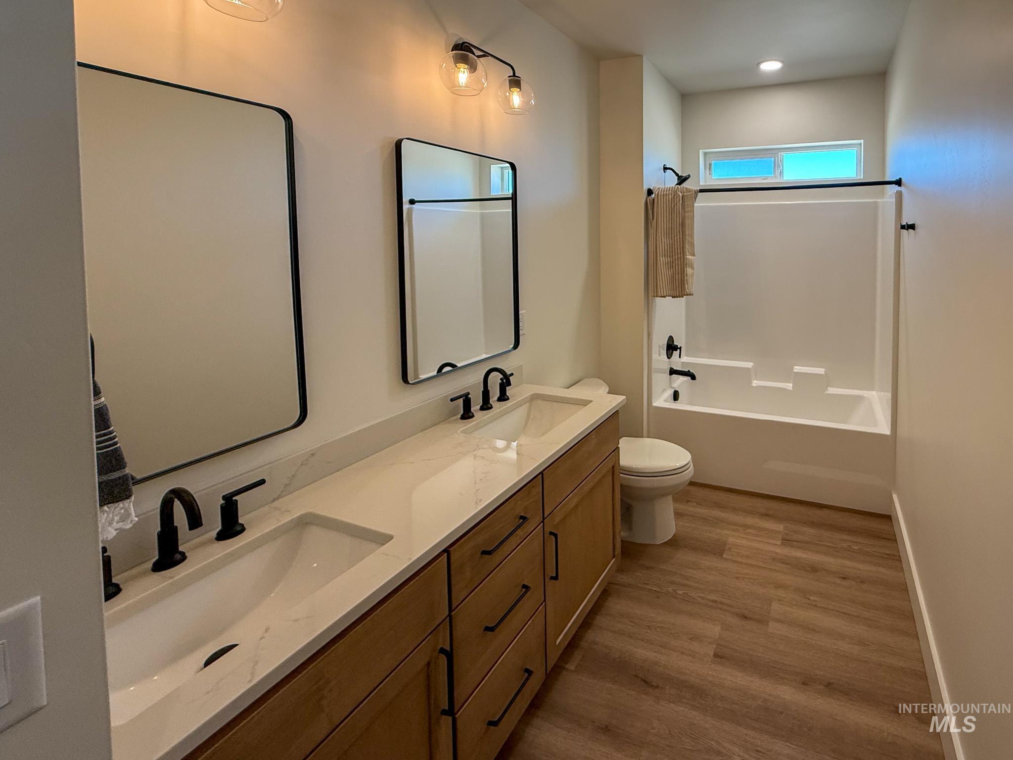 1419 Cardon Court Rupert, ID 83350 - Photo 12 of 15 Double vanity with integrated sinks, quartz countertop, wood-finish cabinetry, and matte black fixtures