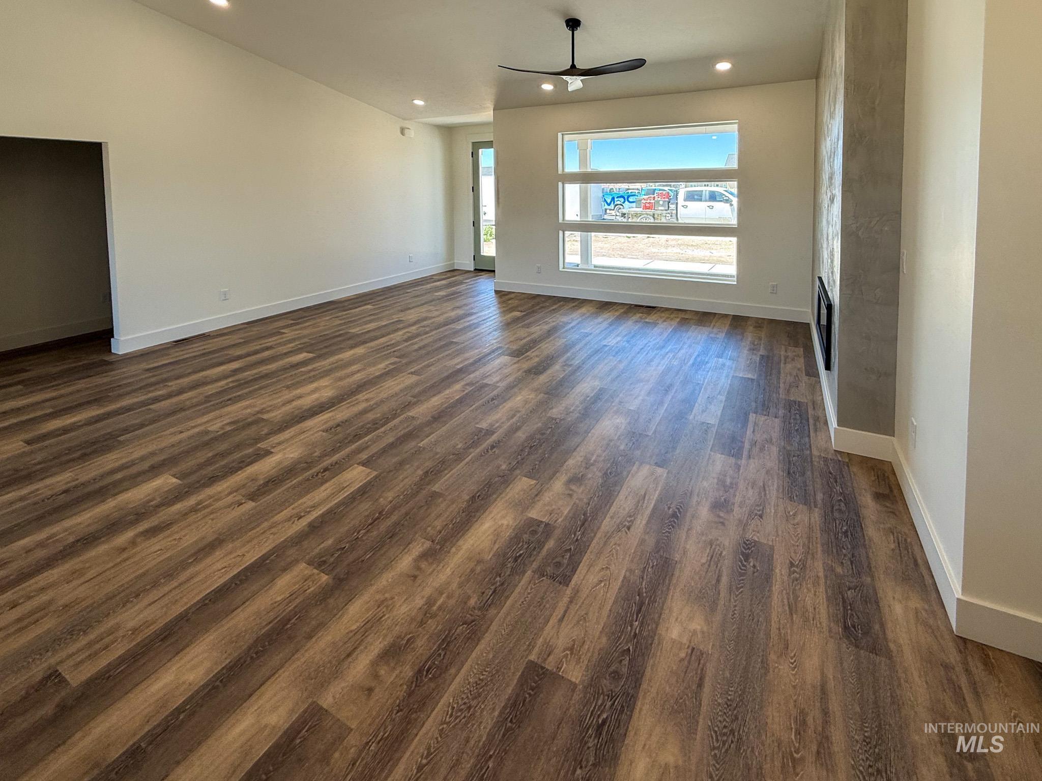 1419 Cardon Court Rupert, ID 83350 - Photo 3 of 15 Spacious living area featuring wood-finish flooring, a modern linear fireplace with a textured surround, and a ceiling fan