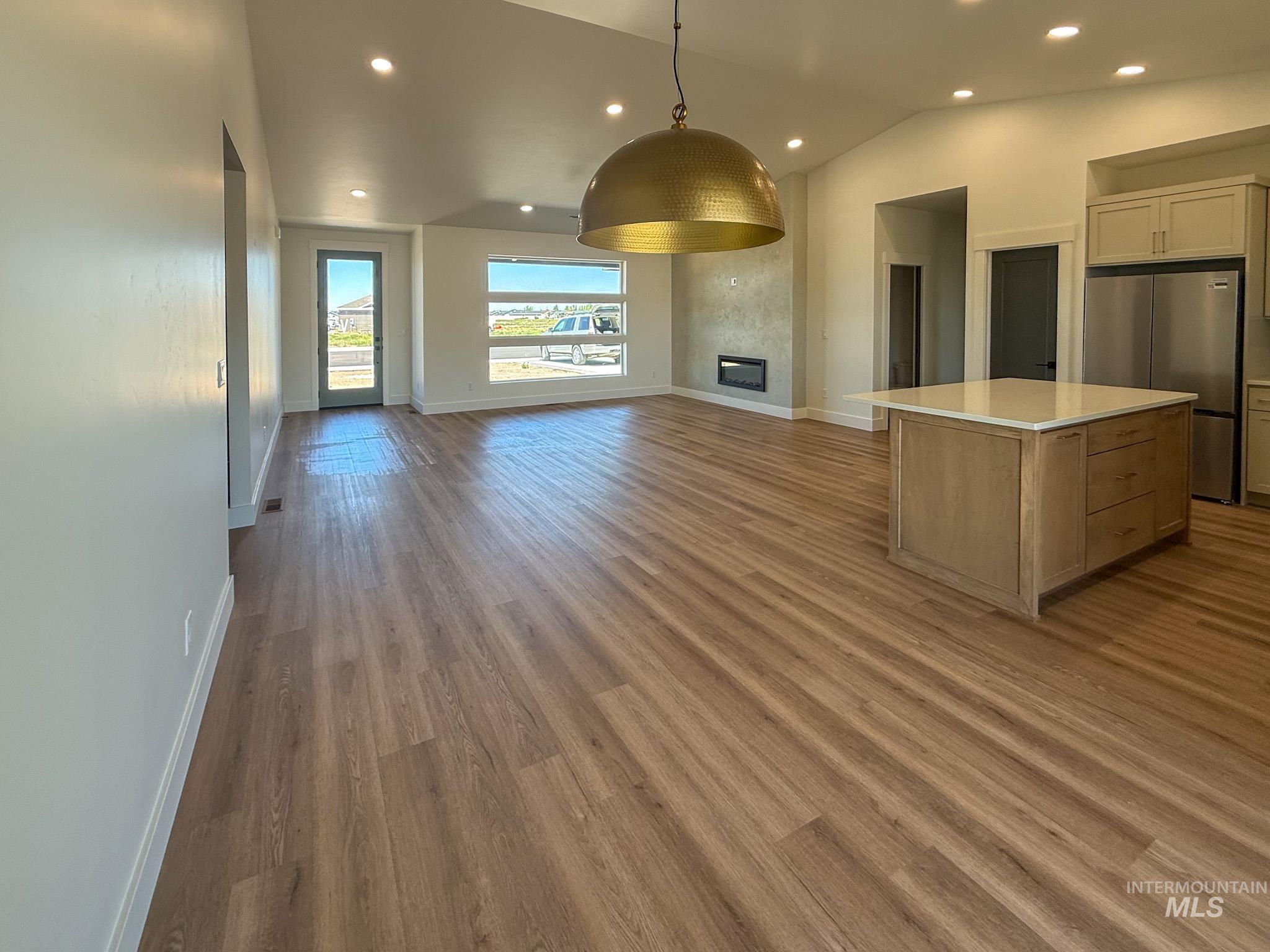 1419 Cardon Court Rupert, ID 83350 - Photo 5 of 15 Spacious open-concept living area featuring wood-finish flooring, a contemporary pendant light fixture, recessed lighting, and large windows