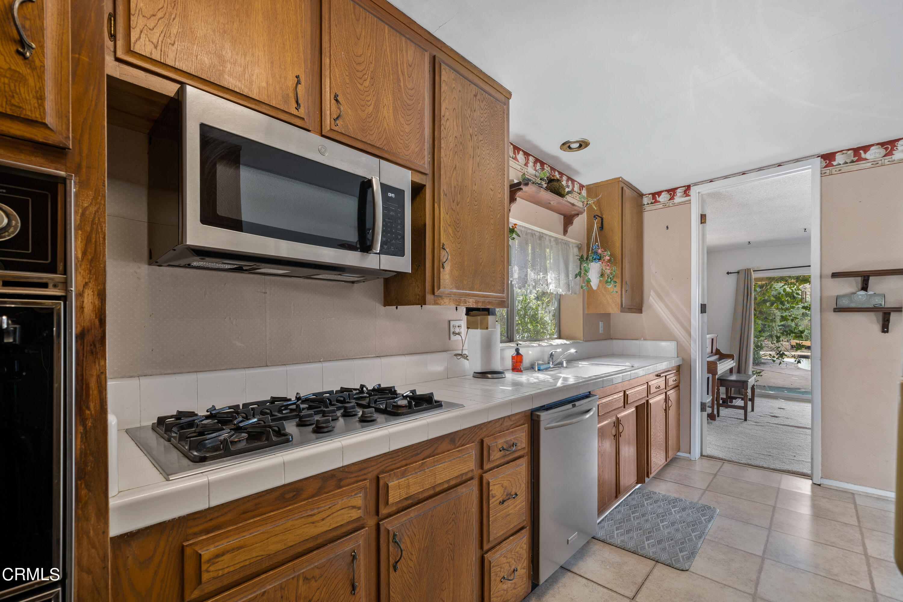7024 Charrick Place Tujunga, CA 91042 - Photo 11 of 45 a kitchen with stainless steel appliances a stove a microwave a sink and cabinets